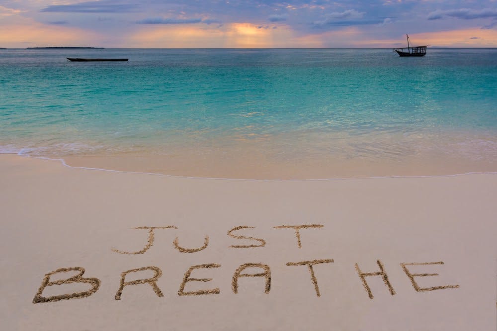 Breathwork headline image: “just breathe” on beach