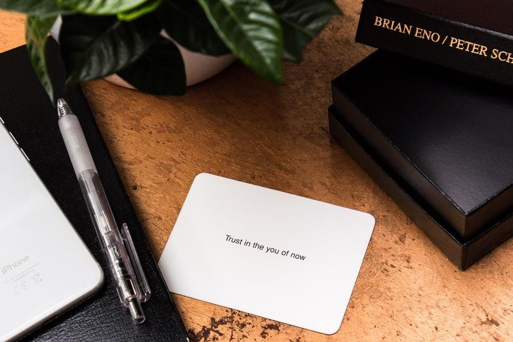 card on a desk with the text: “Trust in the you of now”