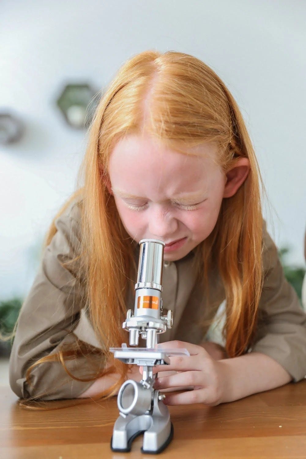 A girl looking in to the microscope.
