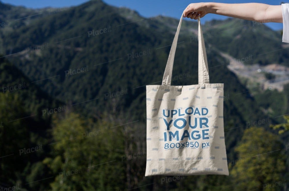 woman holding a tote bag outdoors in the mountains