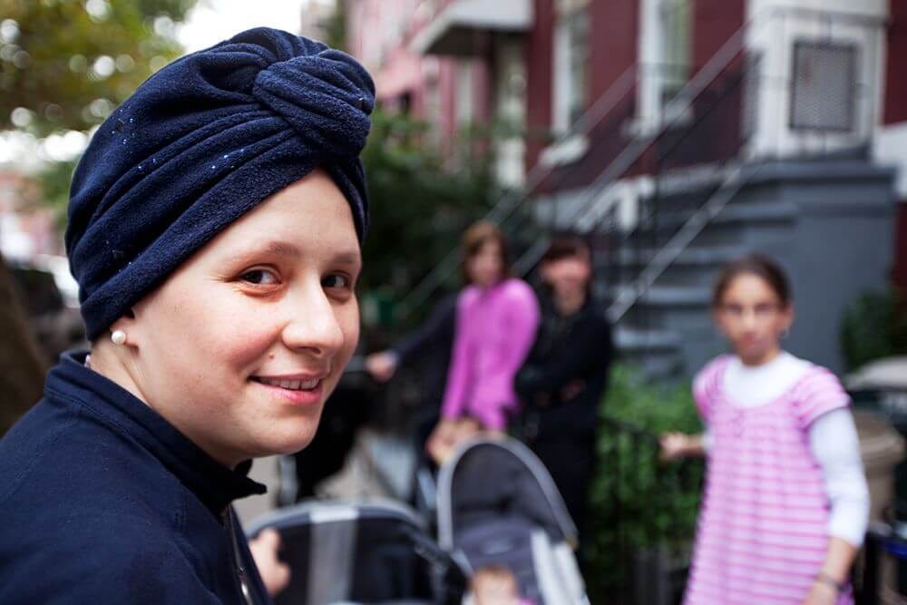 A woman in a navy blue turban smiles slightly for the camera in NYC.