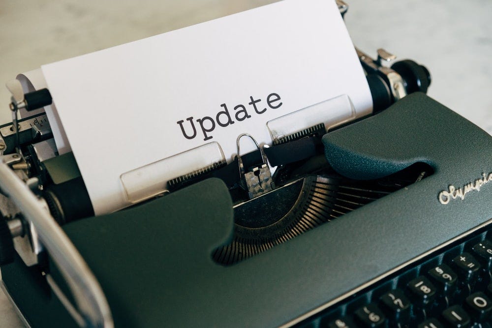 Máquina de escrever com um papel escrito “Update” (Atualização em inglês)