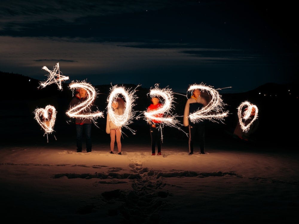 Um grupo de pessoas manuseando sparklers enquanto fazem um desenho de “2022” com algumas estrelas e corações. Fonte: Kenta Kikuchi