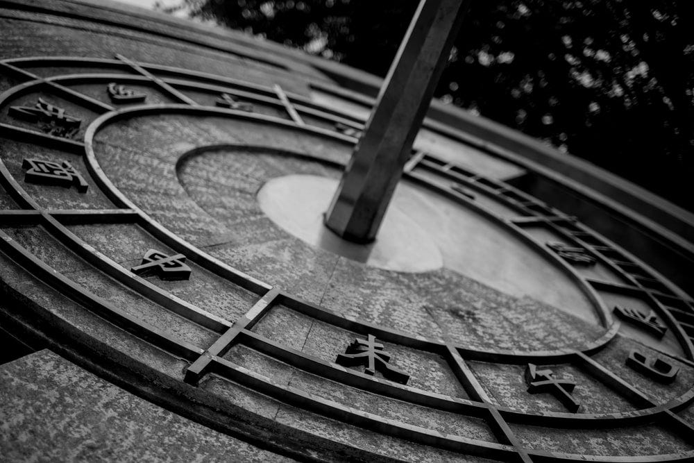 A grayscale close-up of a sundial.