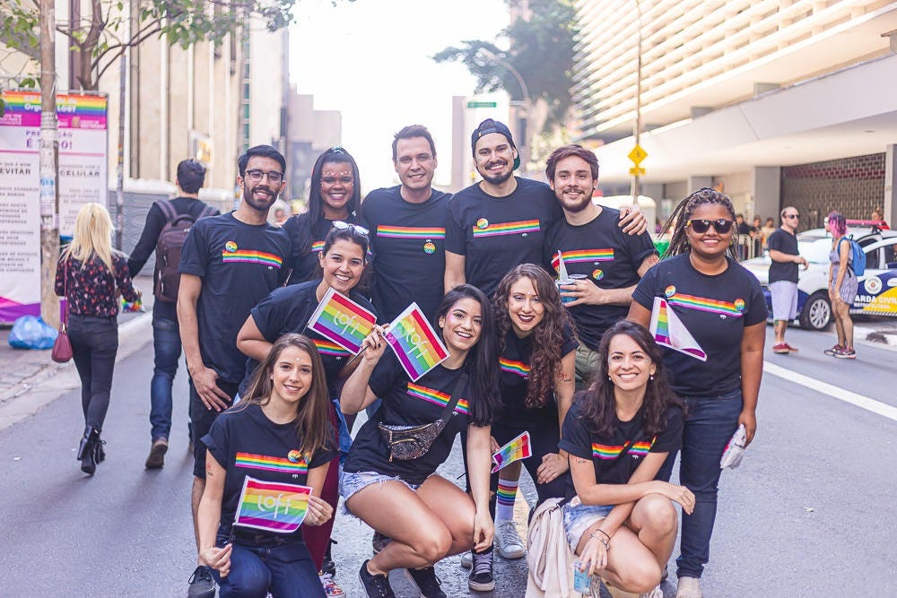 Pessoas da Loft na Parada LGBTQIAP+ do ano de 2019. Elas estão usando camisetas feitas para a data, assim como bandeiras do orgulho.