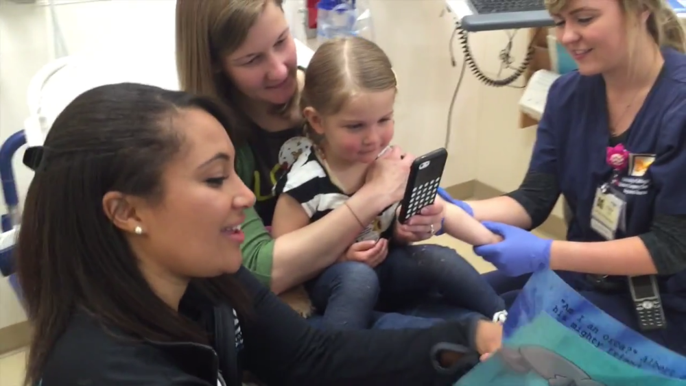 A child life specialist distracts a patient in the ER using SpellBound.