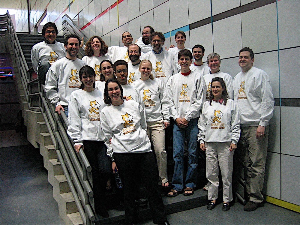 18 people standing on a staircase wearing Scratch shirts
