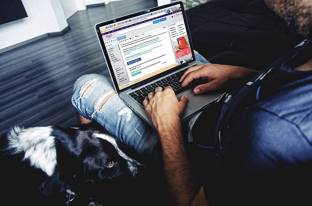 Guy sitting with his laptop and surfing the internet