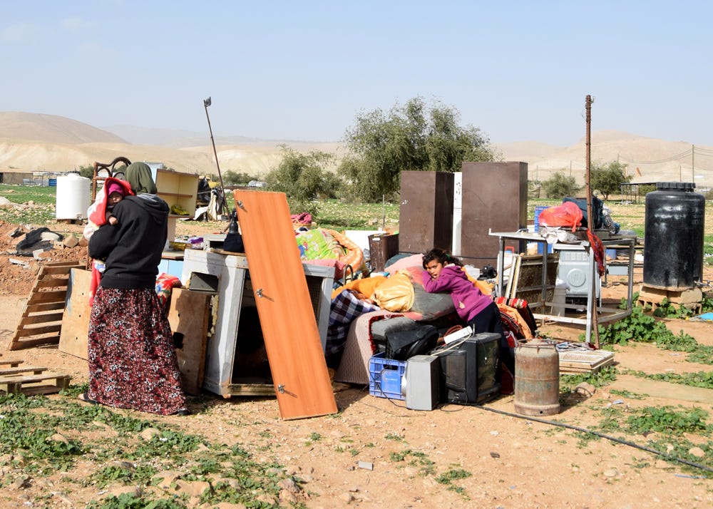 Una familia junto a las pertenencias que pudo salvar de su casa demolida en Fasayil al Wasta, 20 de enero de 2016. (Foto: Aref Dagarmeh / B'Tselem)