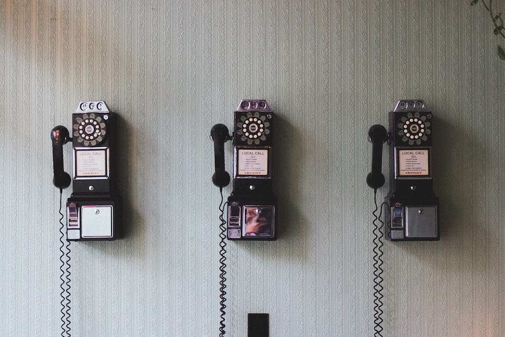 An image of rotary pay phones mounted on a wall