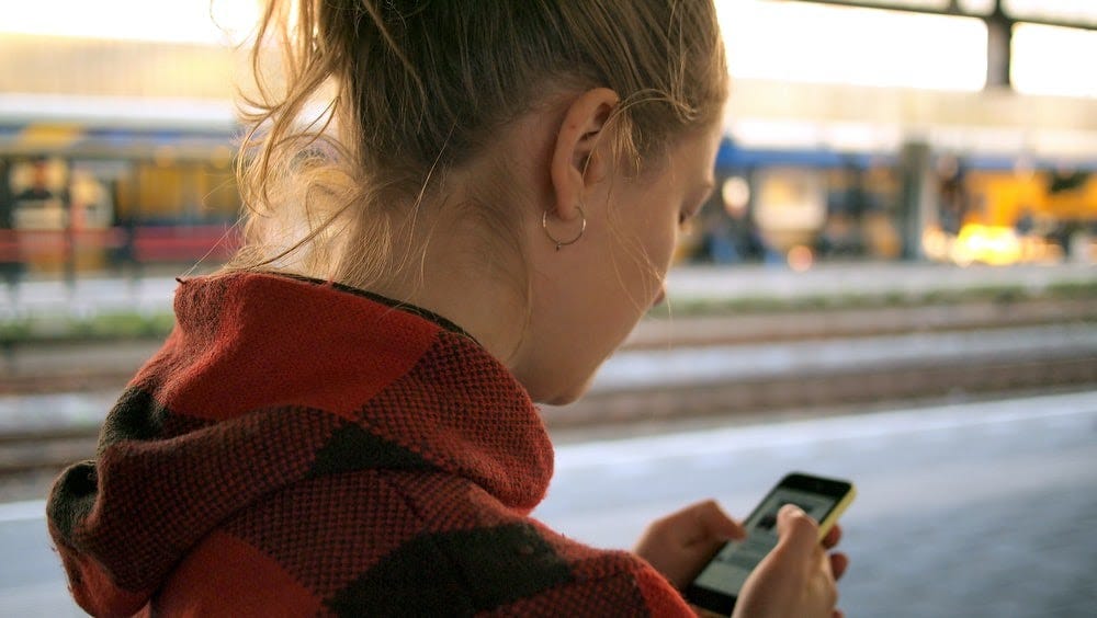 Girl reading messages on her mobile phone