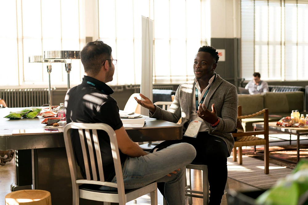 Two men sitting in a hotel lobby and talking