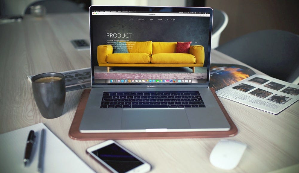 Landing page with a yellow sofa on Macbook