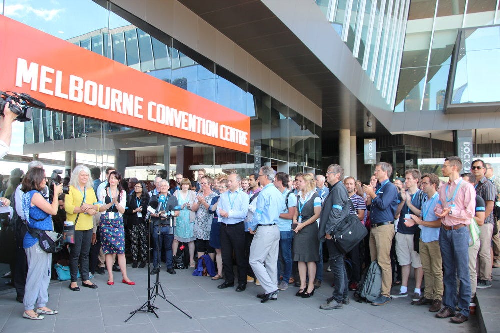 Over 100 climate scientists attending the Australian Meteorological and Oceanographic Society (AMOS) climate science conference in Melbourne, including international visitors, staged a lunchtime protest expressing disapproval of the restructure and cuts to CSIRO staff and climate research programs. Image by John Englart, Australia, 2016.