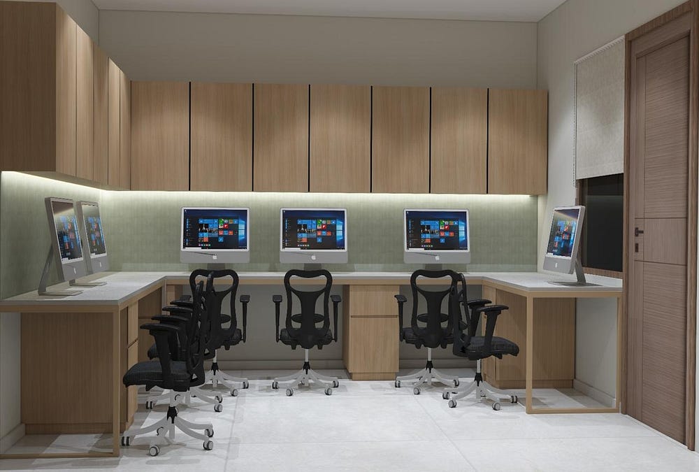 A clean and modern office workspace designed with functionality and aesthetics in mind. The setup includes sleek wooden cabinetry, integrated under-cabinet lighting, and a spacious white workstation layout. Ergonomic black swivel chairs are paired with desktop computers, creating a professional environment that enhances productivity. The minimalist design, natural textures, and organized storage solutions make this office both efficient and visually appealing.