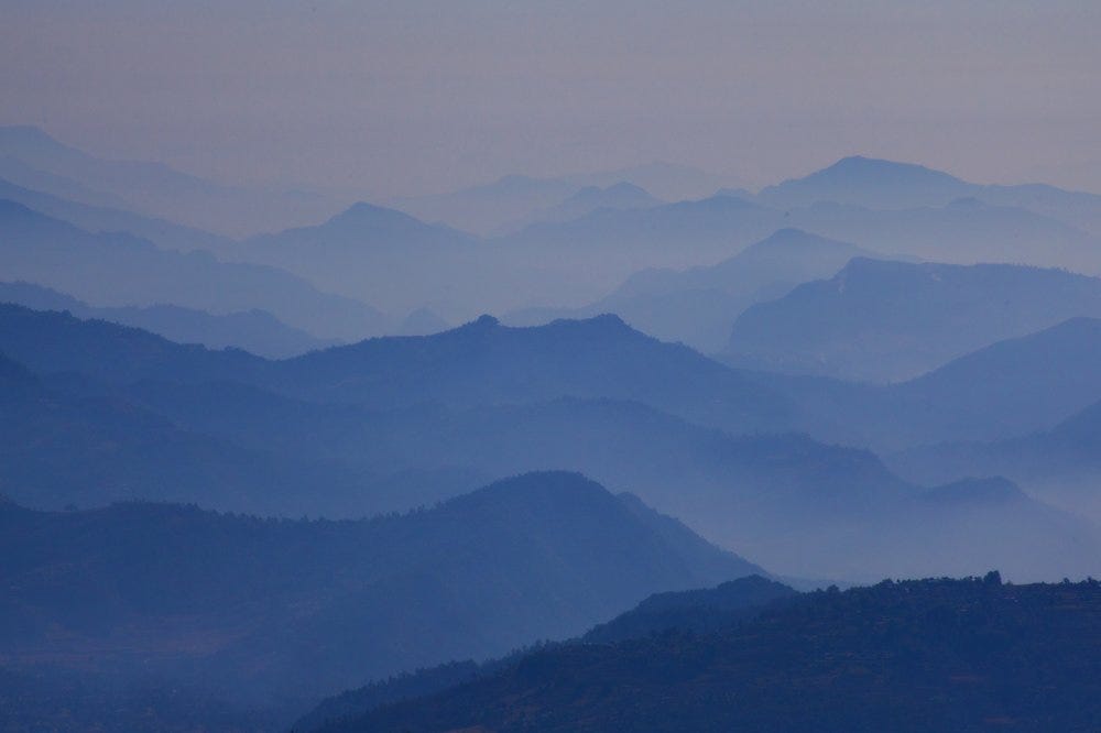 A range of mountains from a distance in various shades of blue