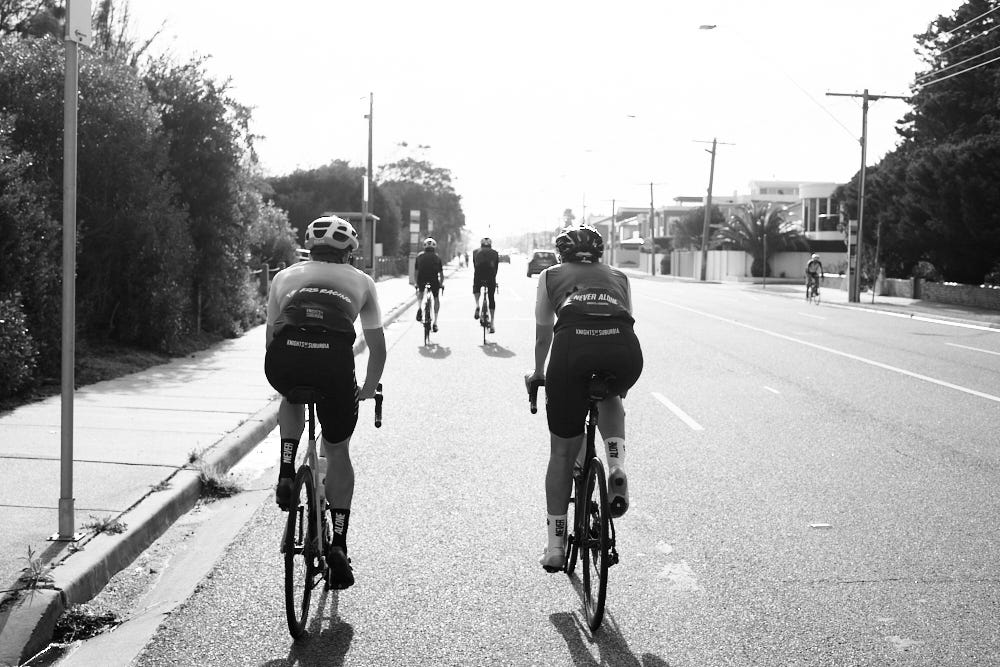 A group of people riding bikes down a street