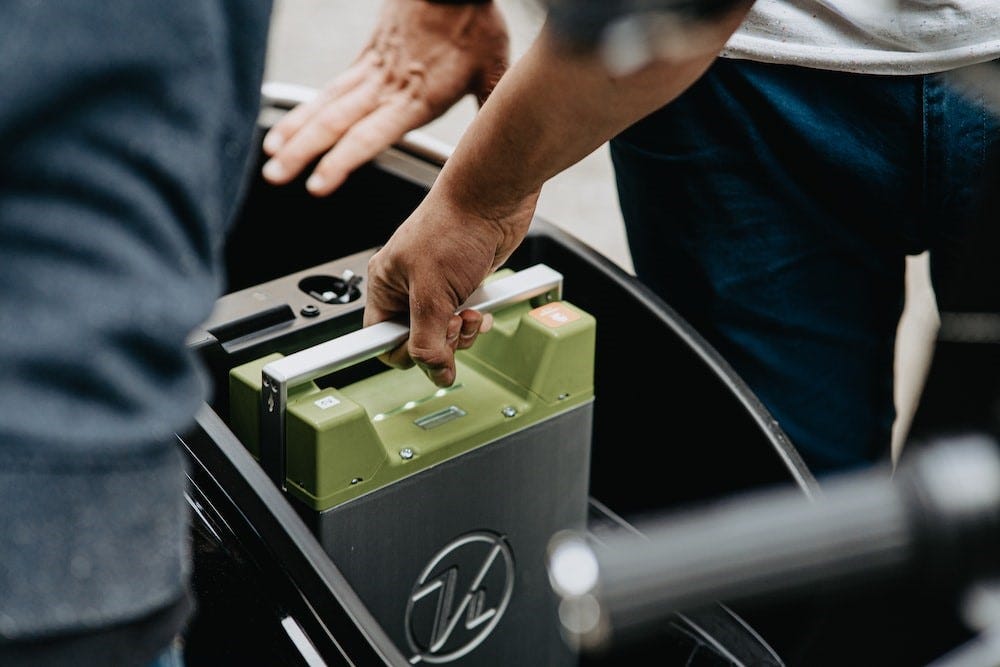 A person holding an electric vehicle battery