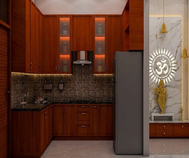A modern modular kitchen designed with rich wooden cabinets, sleek black granite countertops, and warm under-cabinet lighting. The backsplash features textured stone tiles, adding depth and style. Tall cabinets with glass fronts and subtle accent lighting enhance storage and elegance. On the side, a beautifully designed puja area with a marble backdrop, golden deity, and glowing Om symbol creates a spiritual and serene corner, blending functionality with tradition.