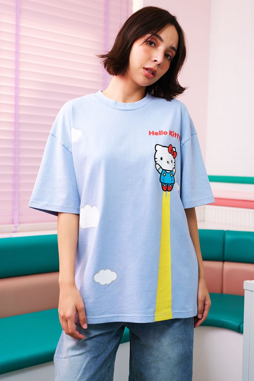 Woman wearing Sky High Oversized T-shirt by Bonkers Corner, smiling.