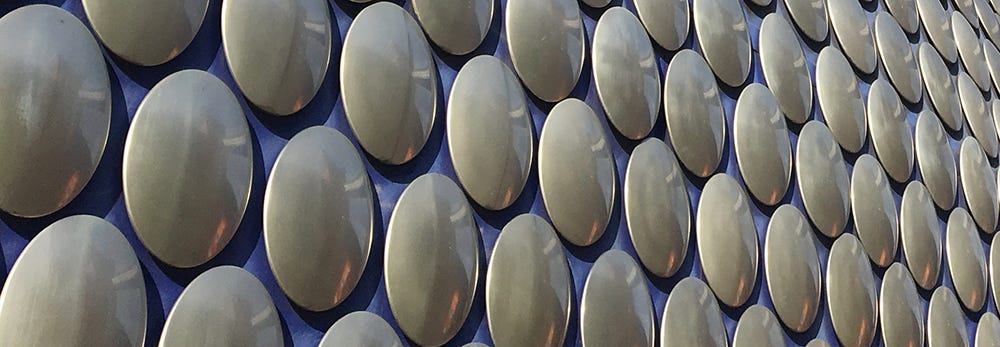 Close up of circular metal studs on the side of the iconic Selfridges building in central Birmingham, UK.
