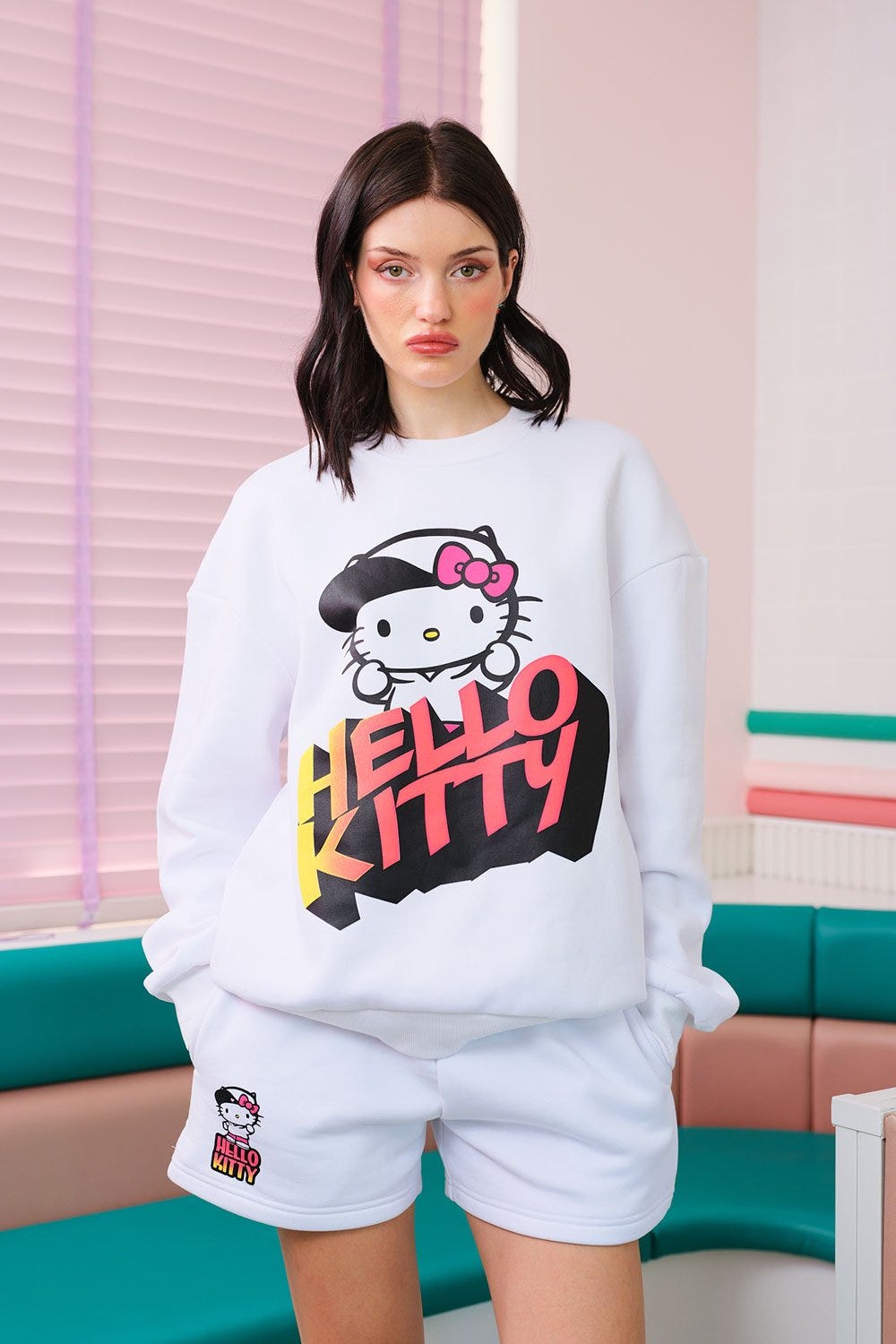 Woman in white Hello Kitty sweatshirt and shorts by Bonkers Corner.