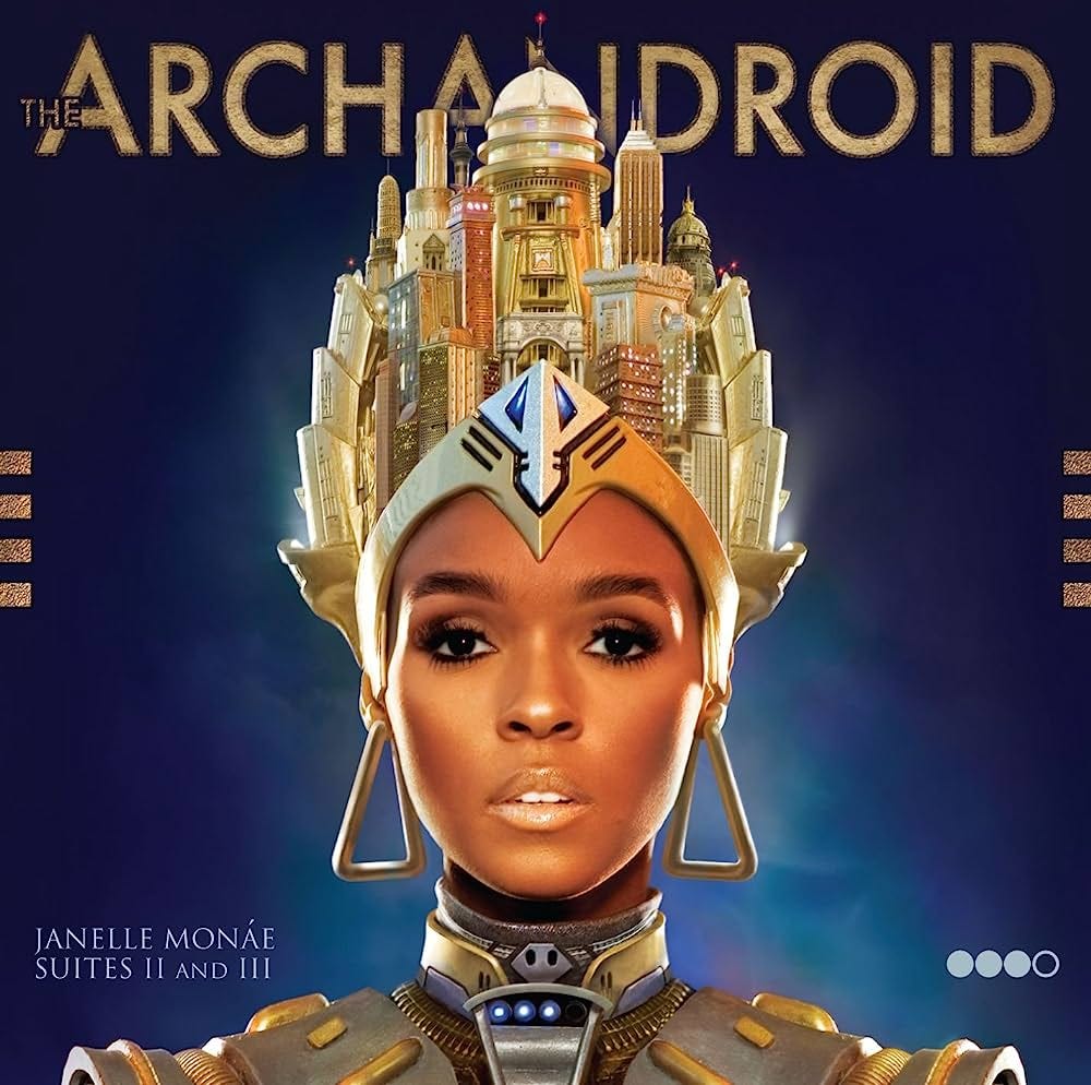 A painting of Janelle Moná’s face with a golden, futuristic crown reminiscint of ancient Egyptian styling. The background is a deep blue, but it is lighter around her face, as if she is emitting light.