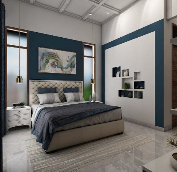 A stylish modern bedroom featuring a tufted beige bed with layered blue and gray bedding, flanked by sleek side tables and golden pendant lights. The accent wall behind the bed showcases deep blue panels and abstract artwork, adding a touch of sophistication. Built-in wall niches with decorative pieces create a contemporary vibe, while large vertical windows allow natural light. The clean lines, soft tones, and cozy textures make this bedroom inviting and restful.