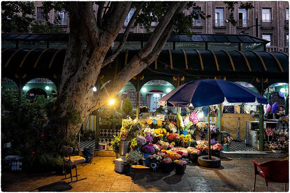 Color image of flower bouquets in front of open-stalls in the evening