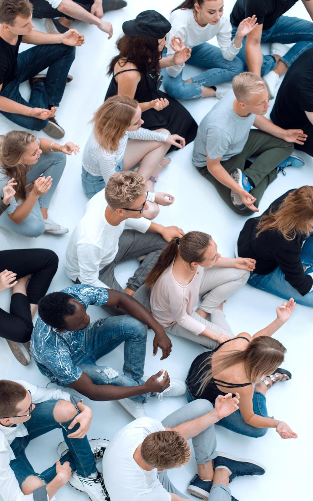 Group of young people seated on the floor meditating