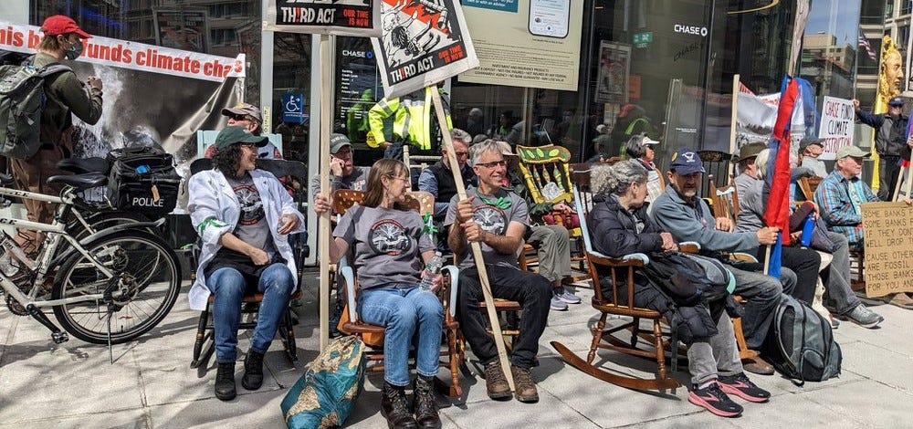 Boomer climate activists in rocking chairs block the entrance to Chase Bank in Washington DC