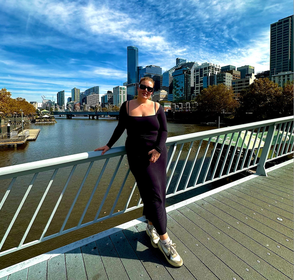 Woman in black dress overlooking Melbourne’s skyline and Yarra River