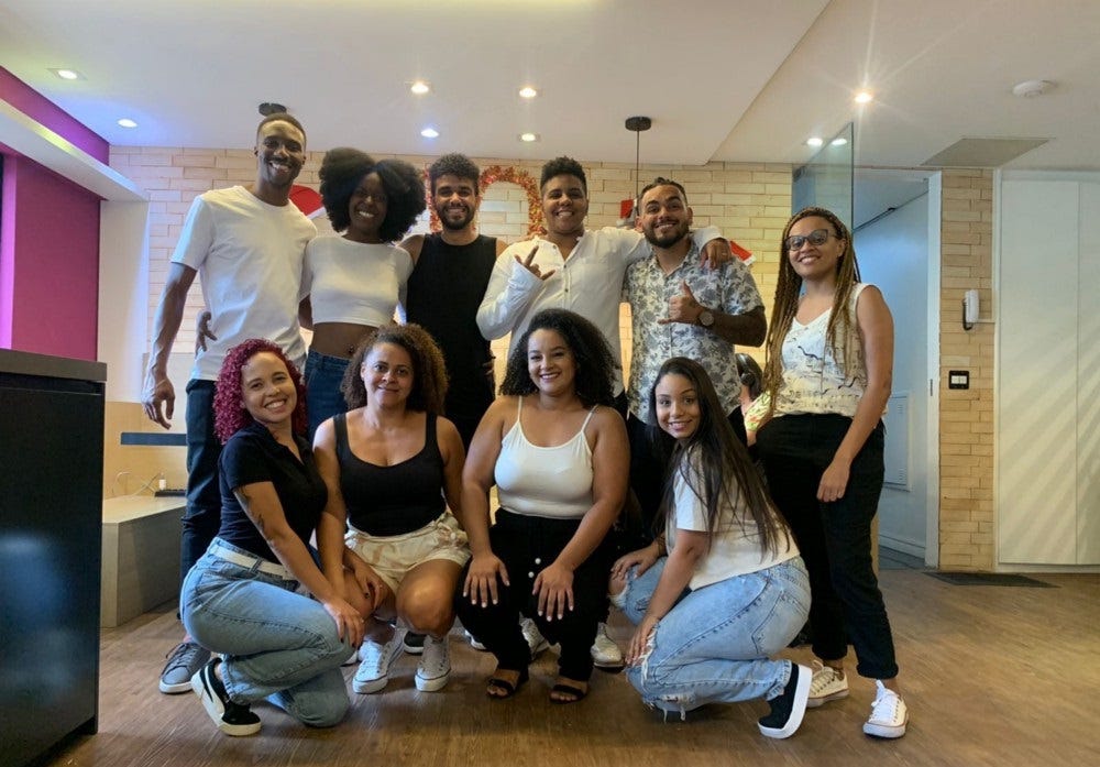 algumas pessoas que fazem parte do grupo Afro Convenia. Elas estão posando para a foto no escritório da Convenia em São Paulo.