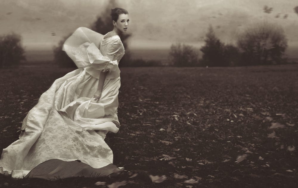 A woman in a wedding dress looks behind her while running away.