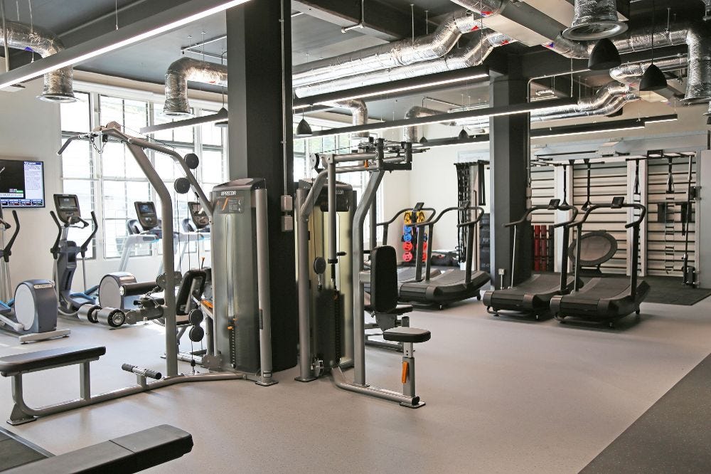 Image of the office gym in London, showing resistance machines, running machines, and cross trainers.