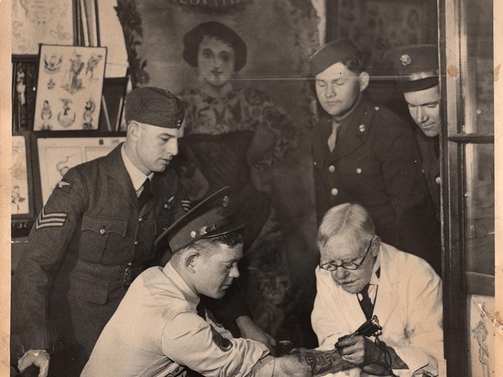 U.S. soldiers visit tattoo artist George Burchett (1872–1953)