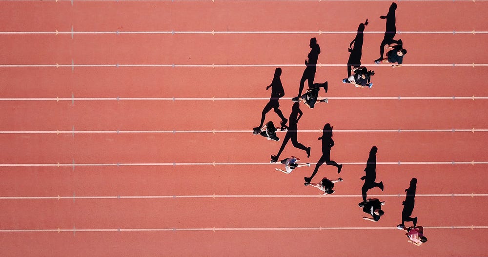 Track runners pictured from above, running in separate tracks.