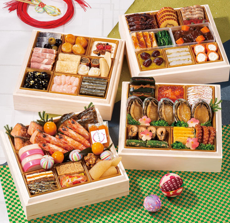 New Year's food called osechi-ryori. Four wooden boxes divided into square sections. Each section contains one or many different types of beautifully presented food: shrimp, abalone, rolled omelette, beans, dried fish, etc.