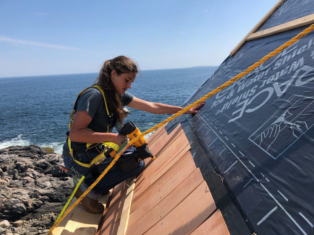 Young woman installing roofing shingles