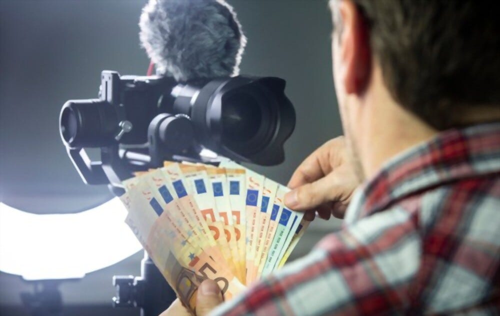 A man streams online while recording a video with a mirrorless camera and ring light, counting the money he has earned from his YouTube channel.