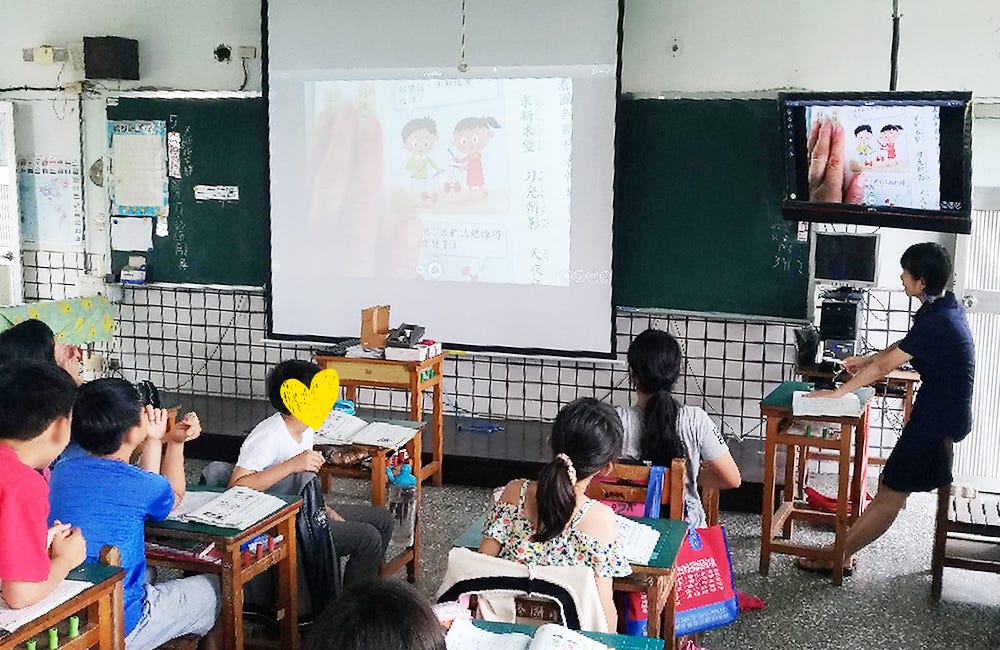 A teacher displaying a Mandarin textbook to the entire class with the Ziggi-HD Plus.