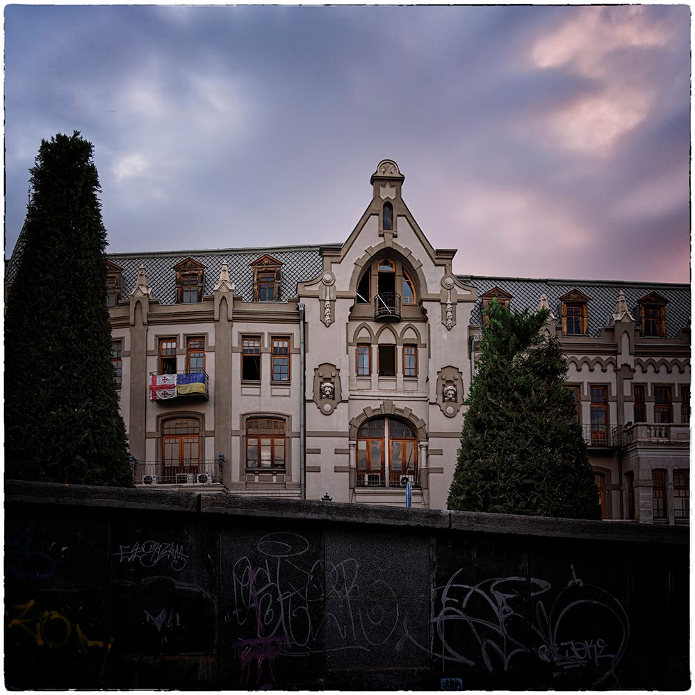 Color image of a stately 1800s building in Tbilisi, Georgia with a cloudy sky in the background