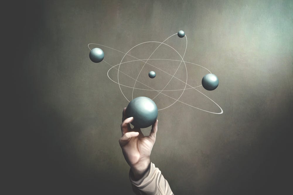 Hand holding a ball to represent the movement of planets and quantum physics | Greg Lindberg’s Riveting Eighth Chapter on Quantum Physics and Leadership