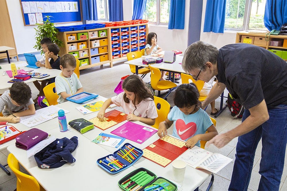 A German School Jakarta teacher is helping his primary students during class