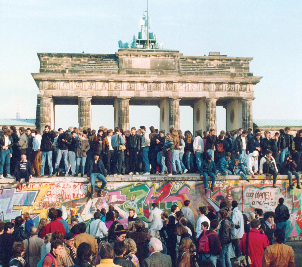 Hundreds of people over the Berlin Wall on the day it fell, right in front of the Brandenburg Gate.