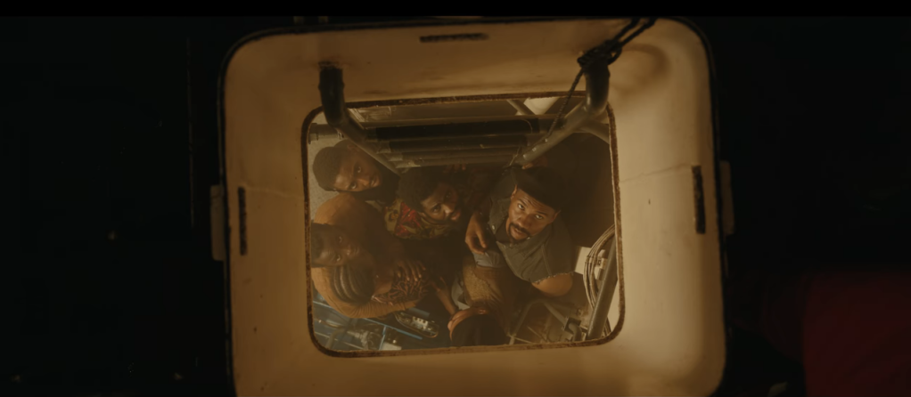 Six people down the hatch of a compartment, cramped below the deck of a ship