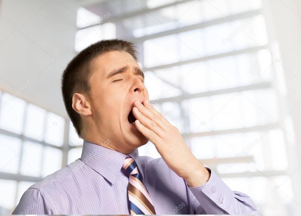 A stock photo of a business man in a mauve shirt and really quite terrible striped tie. He is yawning because this part of the article is so boring.