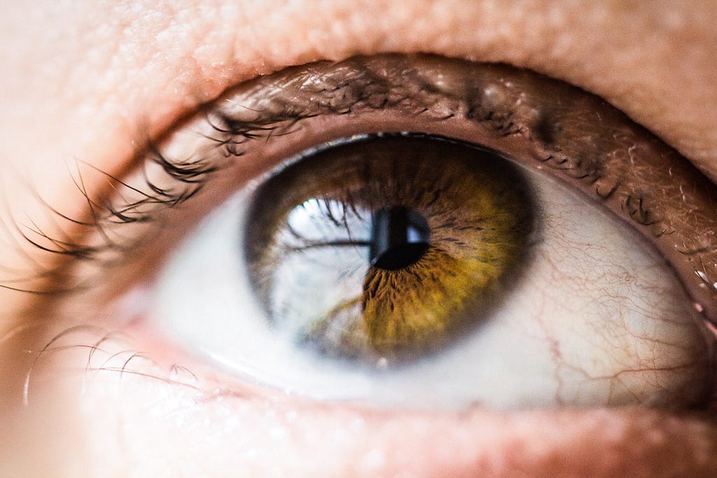 Close-up of a light brown eye, looking upward.