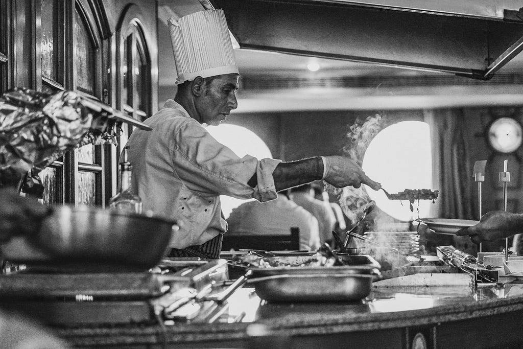 A black and white picture of a chef preparing a catering event