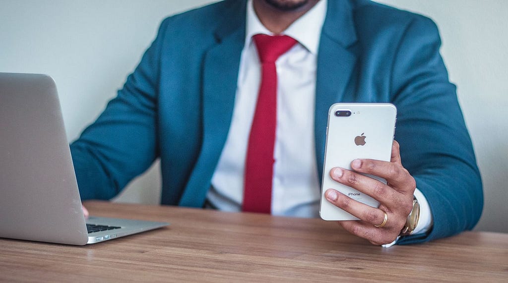 Businessman working on a laptop and looking at a smartphone